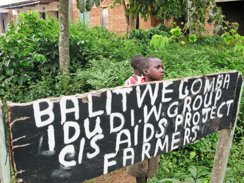 Children behind AIDS Project sign in Uganda