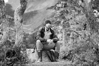 Ben Hammock sitting on rock in forest in Sitka, Alaska