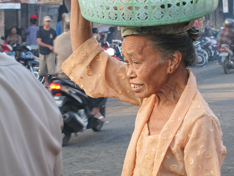woman carrying basket of fruit Bali Indonesia