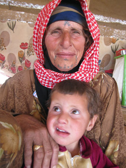 Bedouin woman with facial tattoos holding baby